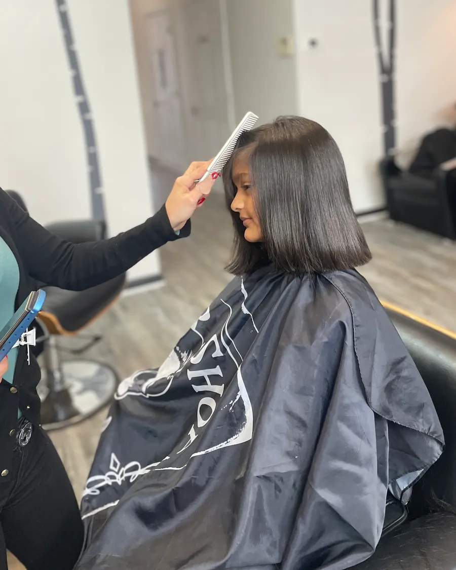 A stylist combing through a fresh bob cut at Milton Salon