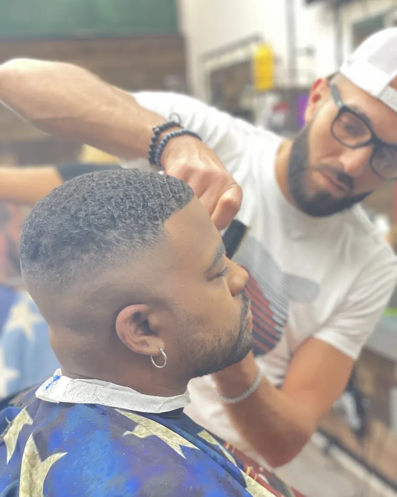 A barber working a fade with clippers