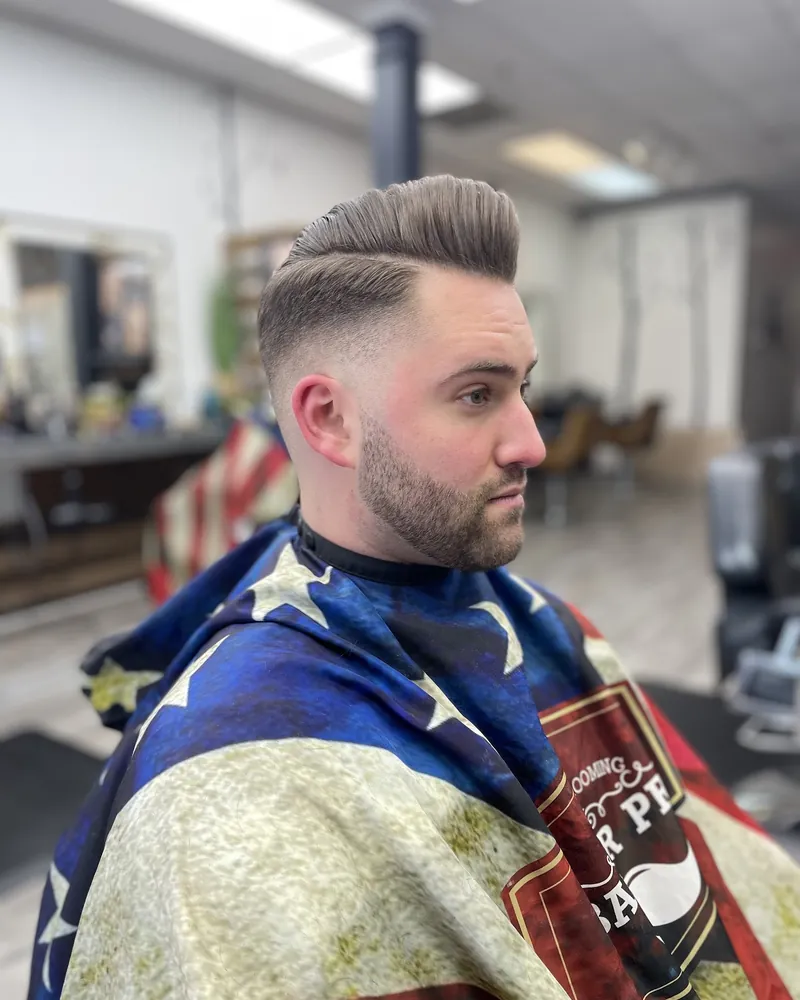 A textured quiff with a taper fade and a full beard, cut at Milton Salon