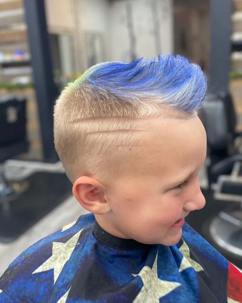 A child's mohawk fade with blue color