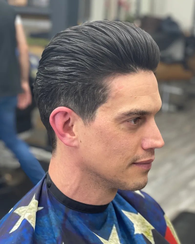 A slicked-back pompadour with a tight fade