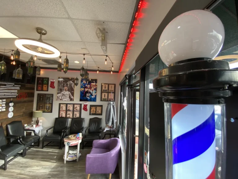 A red, white and blue barber pole beside the shop window