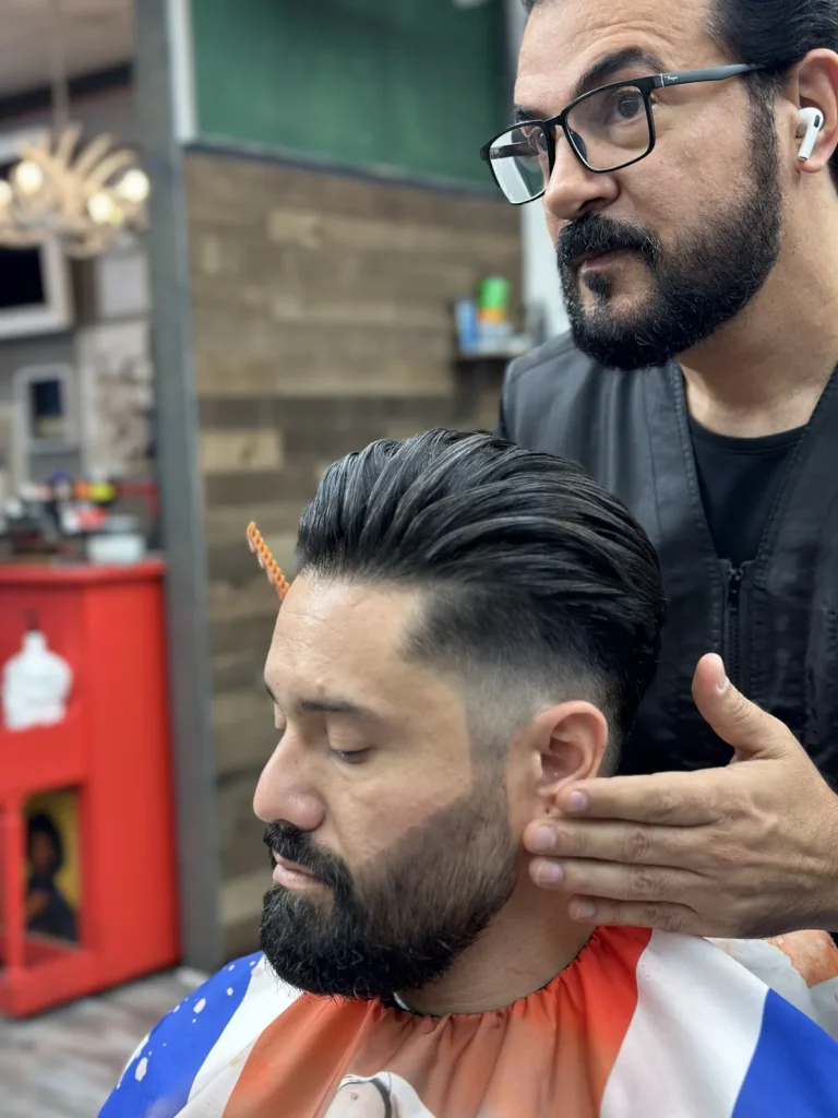 Barber checking the line of a customer’s beard after the cut