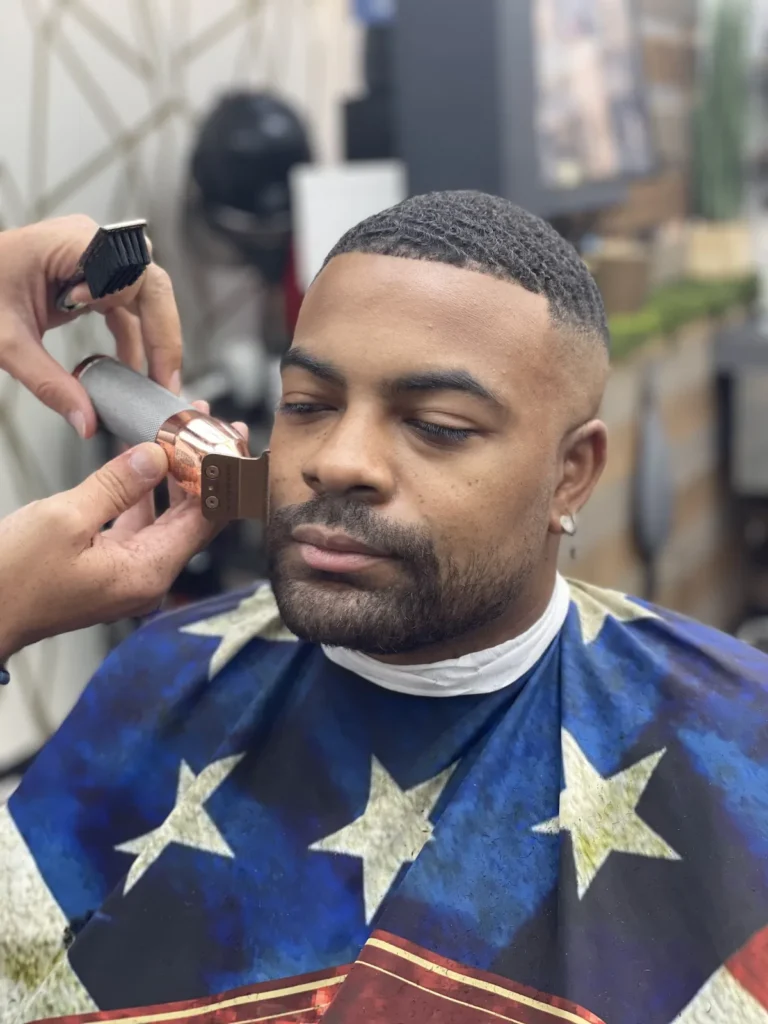 Barber lining up the edge of a customer’s beard with a trimmer