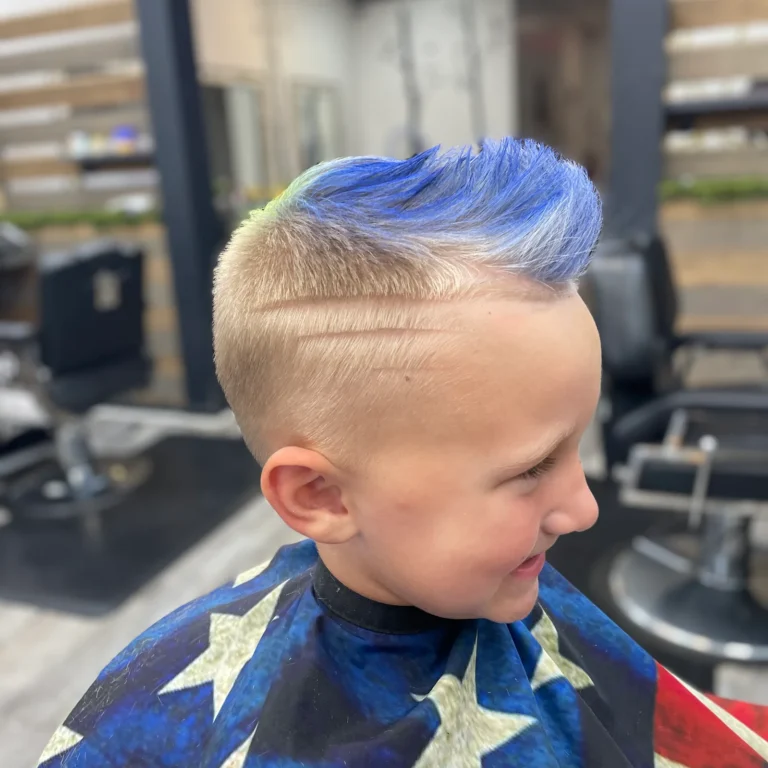 Boy with a blue-tipped mohawk and shaved sides in the barber chair