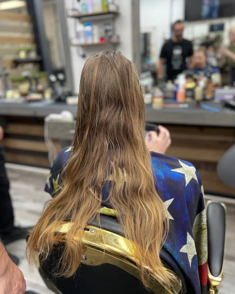 Long layered hair with warm colour, seen from behind in the chair