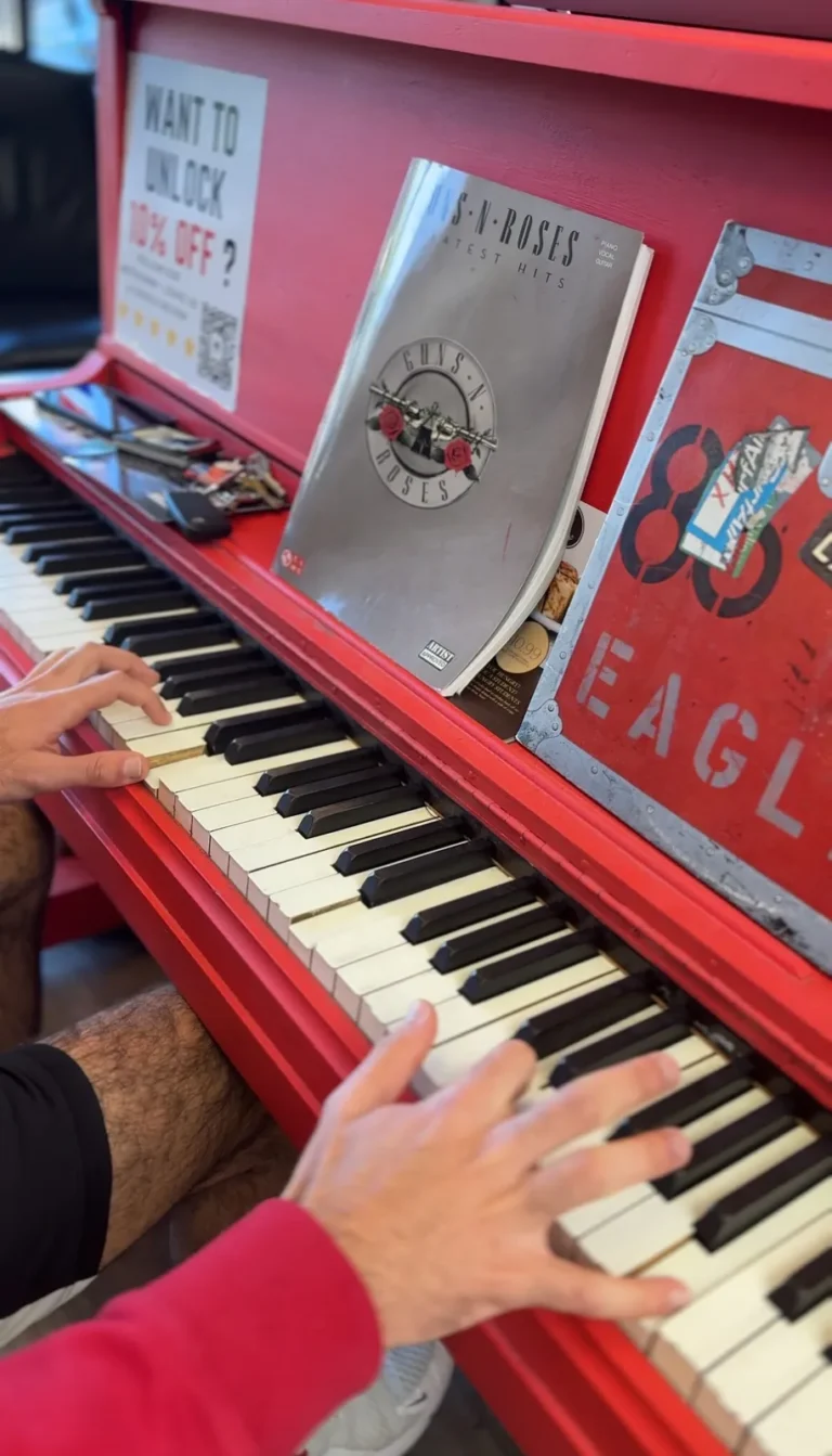 A pair of hands playing the shop’s red piano