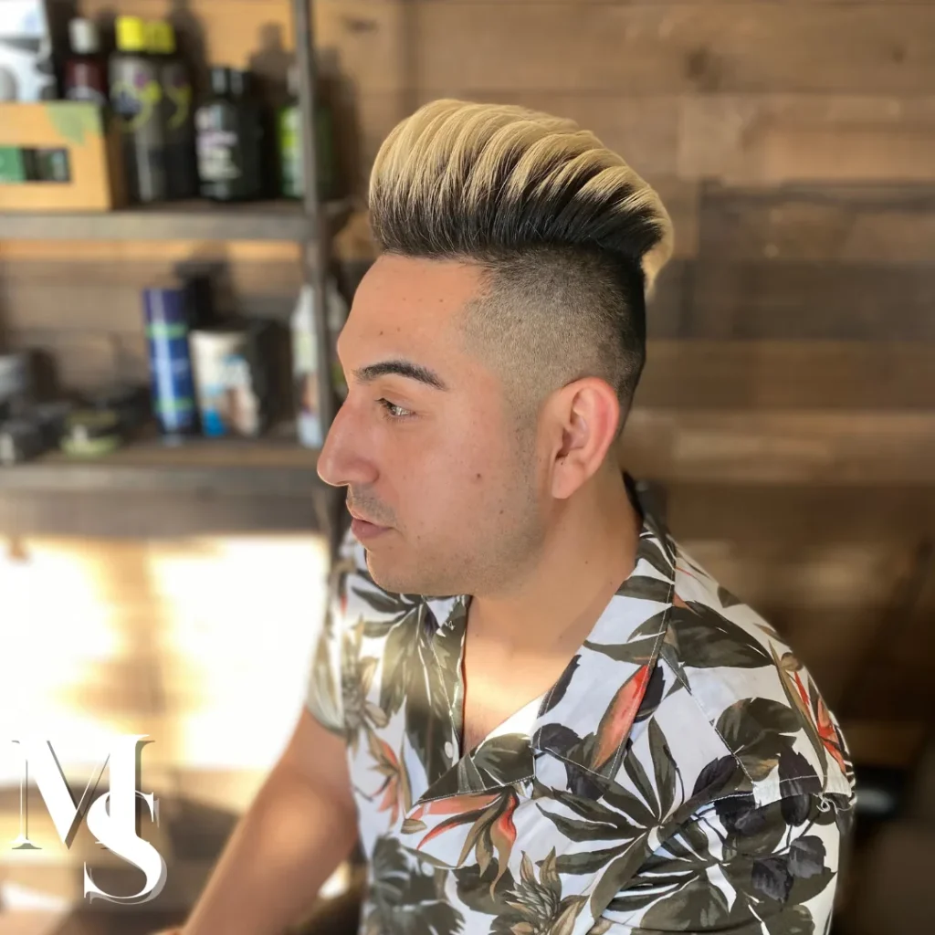 Man with a platinum blond pompadour over a skin fade