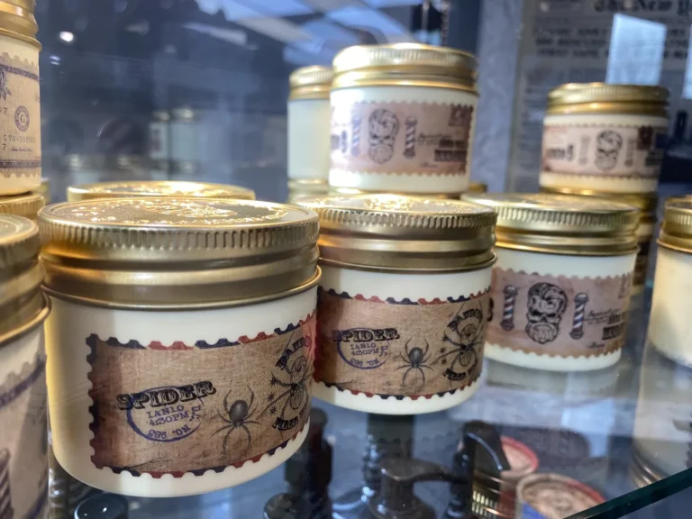 Jars of pomade lined up in the glass display case