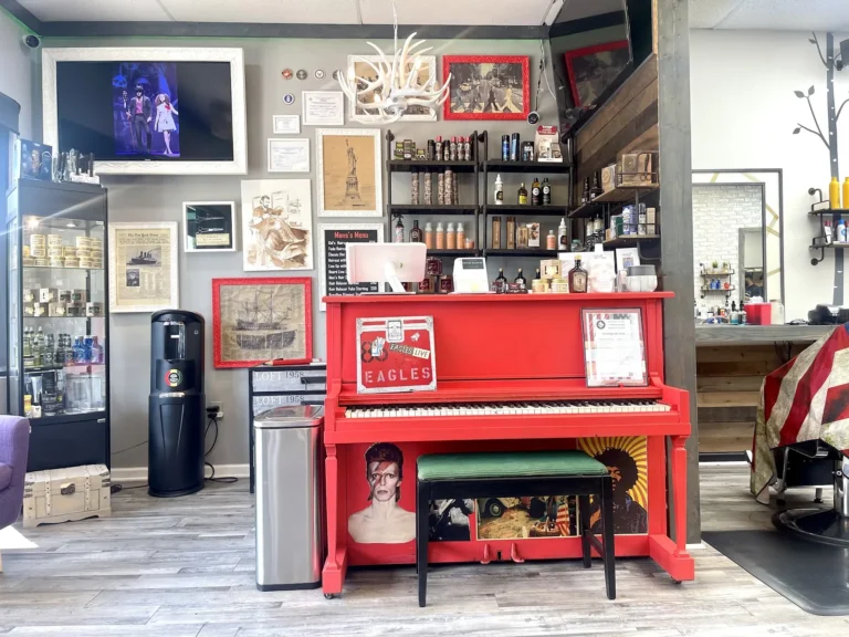 The shop’s red upright piano beside the waiting chairs