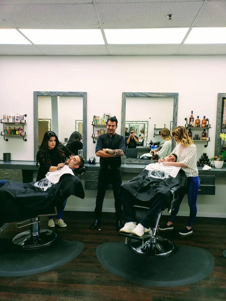 Two stylists working at the salon chairs at the back of the shop