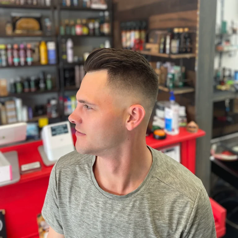 Man with a short crop and a high skin fade, standing by the front counter