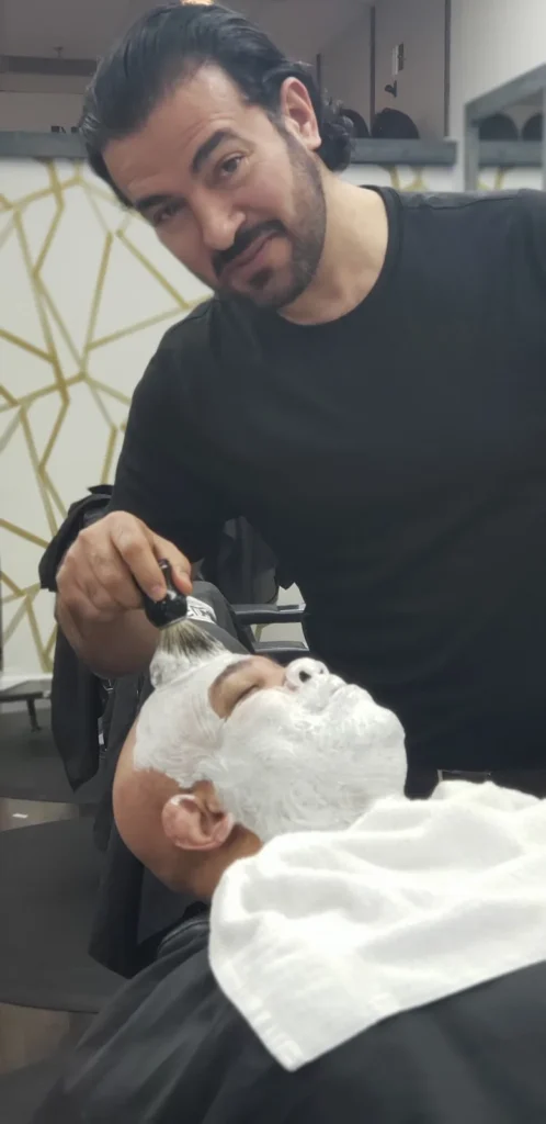 Customer reclined with shaving lather on, mid straight razor shave