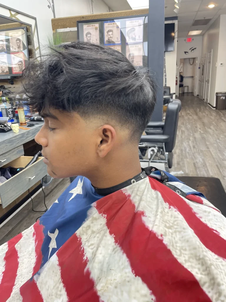 Teenager with a textured fringe and a low taper, side view