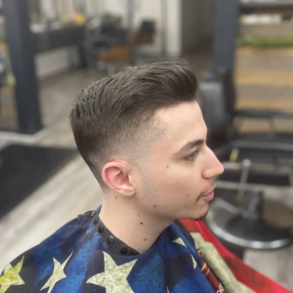 Young man with a textured quiff and a mid fade, side view in the shop