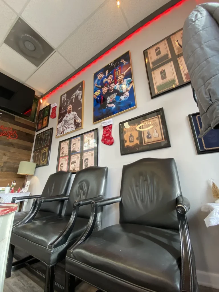 Two leather armchairs under a wall of framed pictures